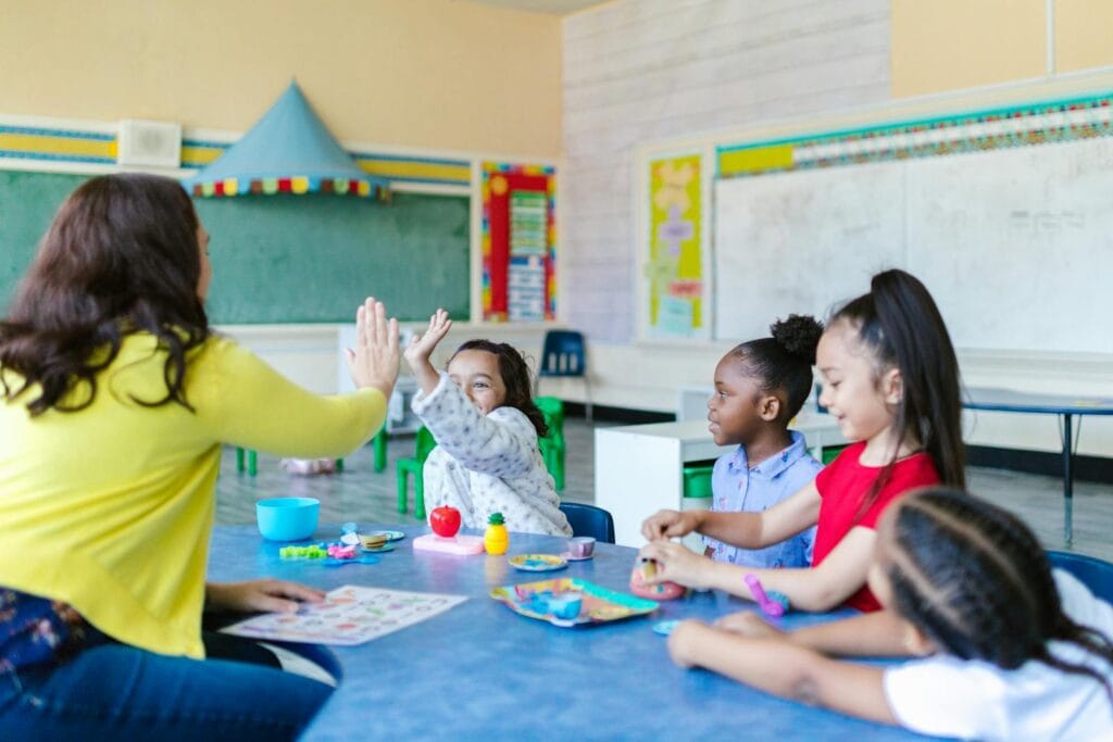 Photo by RDNE Stock project A joyful classroom scene with a teacher and diverse group of children engaging in playful learning activities.